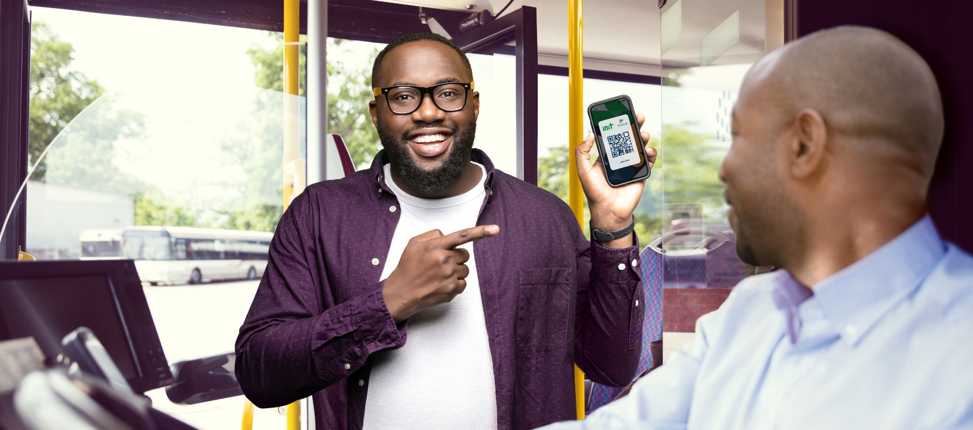  A man boarding a bus showing his mobile ticket to the driver.