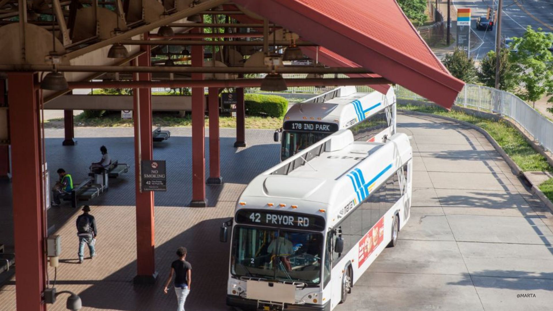 MARTA bus at transfer station with red canopy cover.