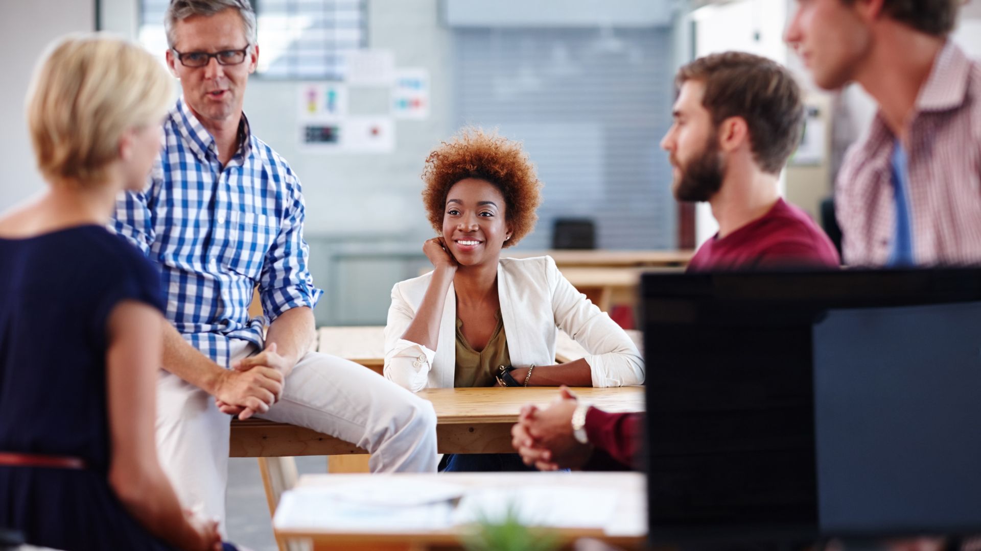 A group of office workers sitting around a table collaborating.