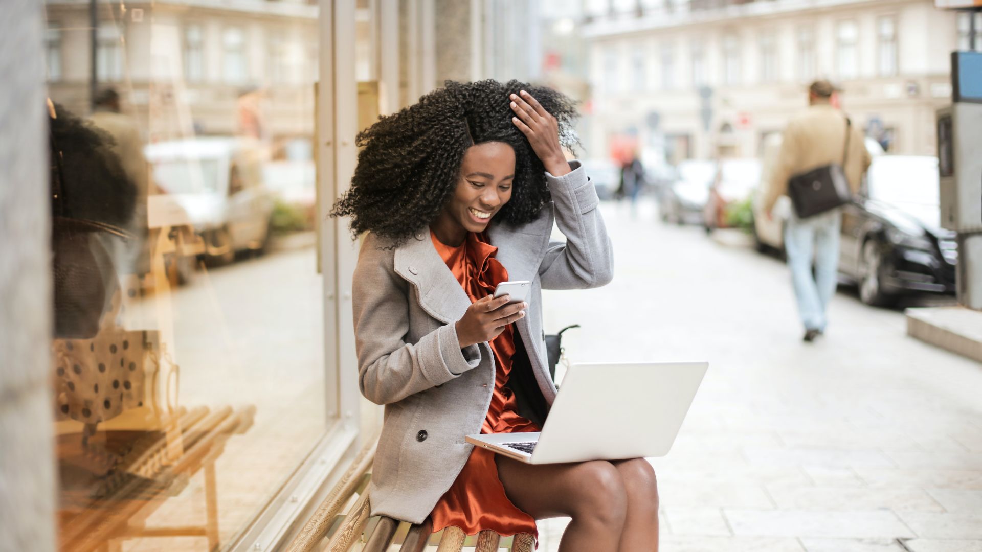 Woman sitting on a bench checking her phone.