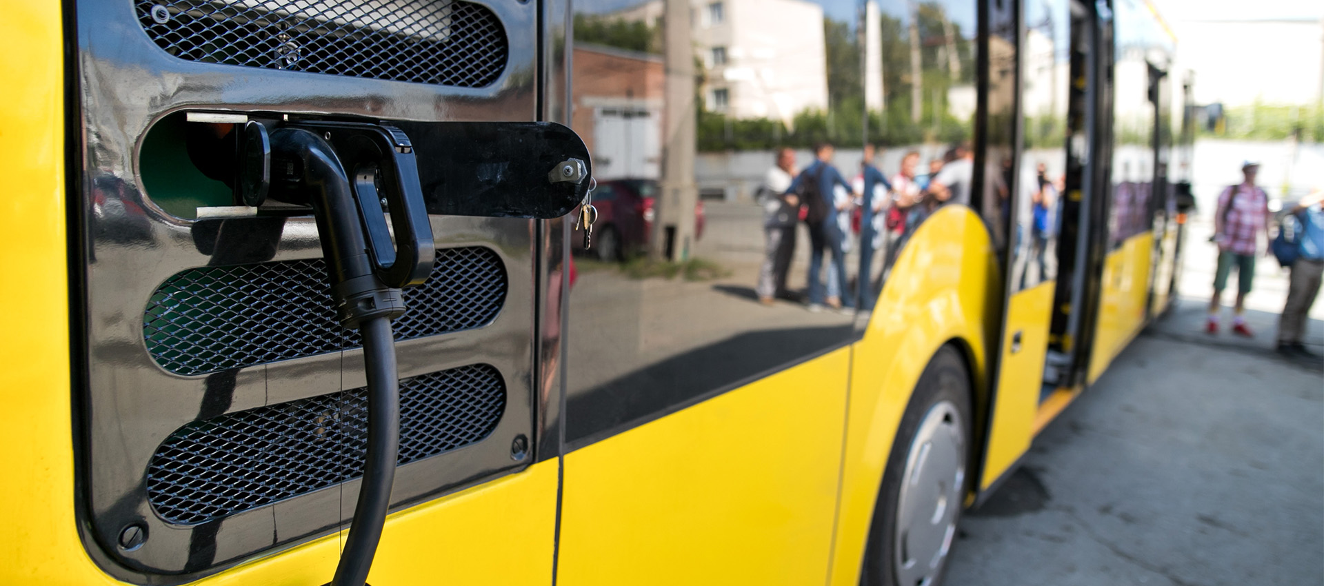 Up close view of yellow electric bus charging.